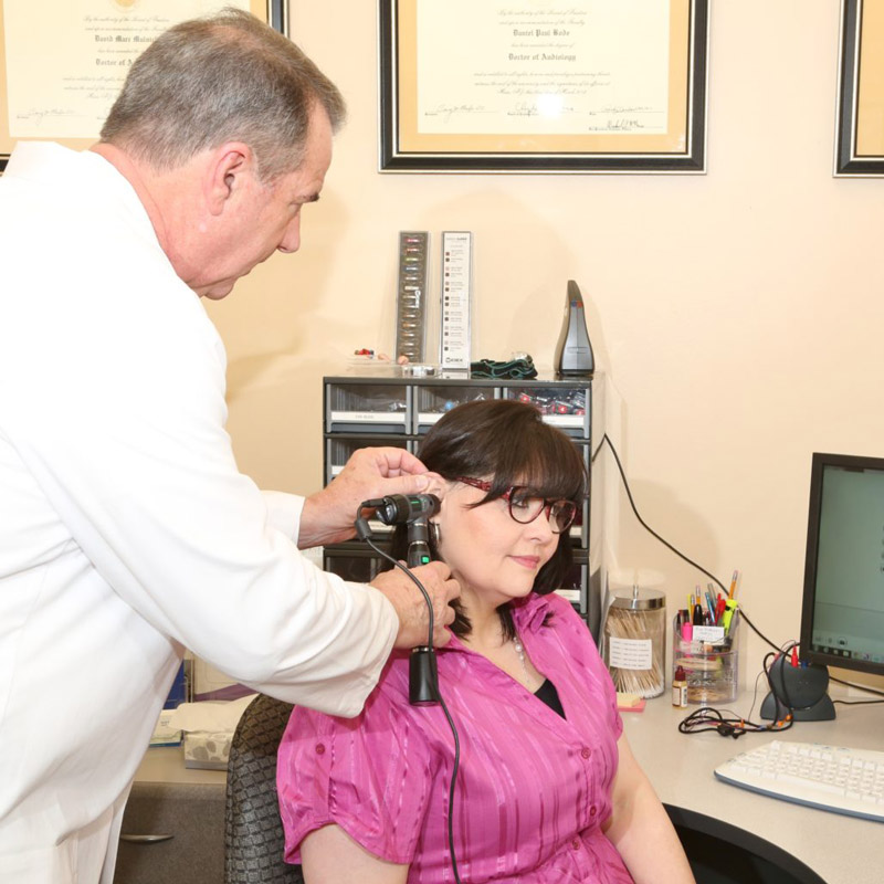 Dr. Dan Bode performing a hearing exam on a patient