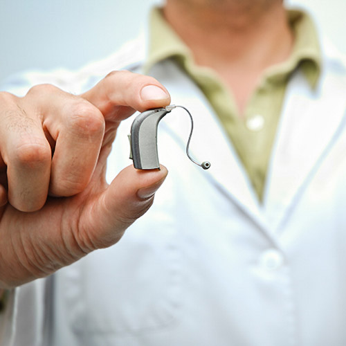 a doctor holding a hearing aid
