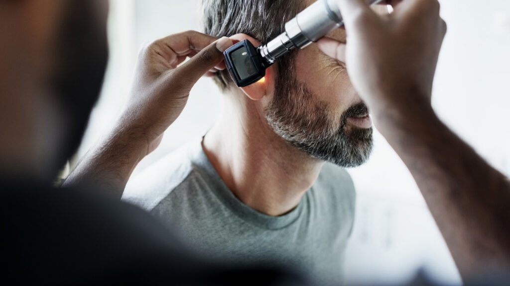 Veteran receiving ear exam from audiologist during hearing care appointment in Southeast Louisiana